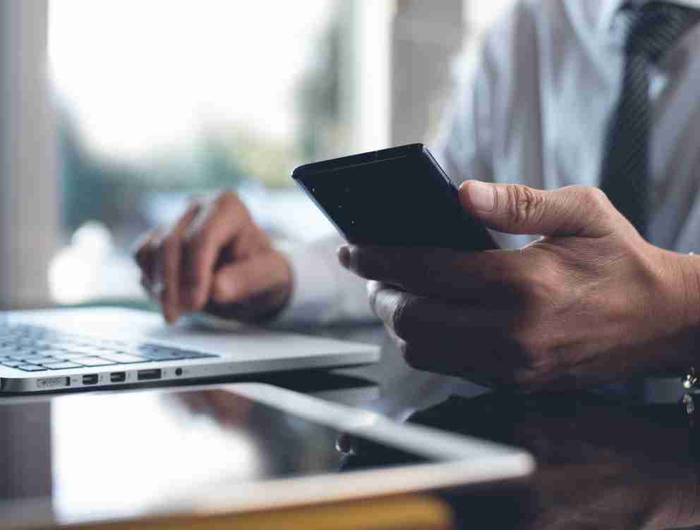 Image of a phone and laptop belonging to a business professional.