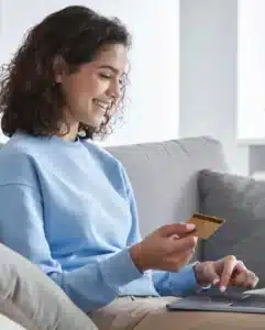 Woman making an online payment and attempting to verify payment with credit card scanning on her MacBook.