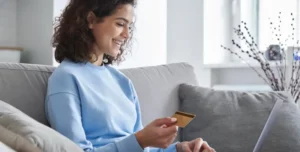 Woman making an online payment and attempting to verify payment with credit card scanning on her MacBook.