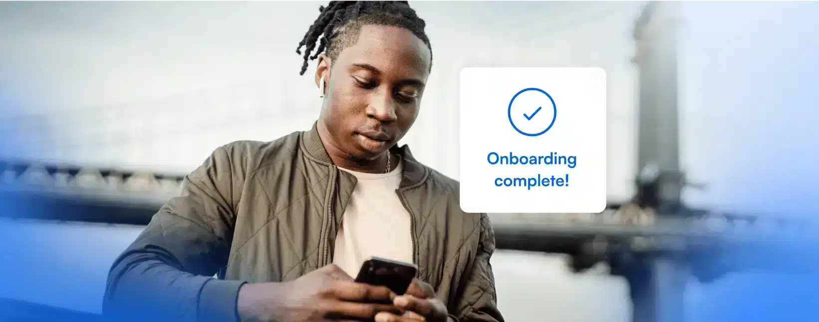Casual dressed user using their phone, with their basic information displayed in the app interface and a 'Onboarding Complete' message.